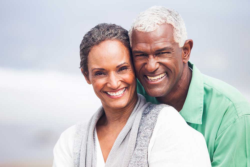 African American seniors smiling together after Cosmetic appointment at Fairbanks Periodontal Associates in Fairbanks, AK