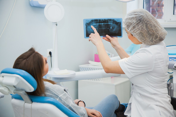 A woman reviewing her x-ray with a dentist at Fairbanks Periodontal Associates in Fairbanks, AK